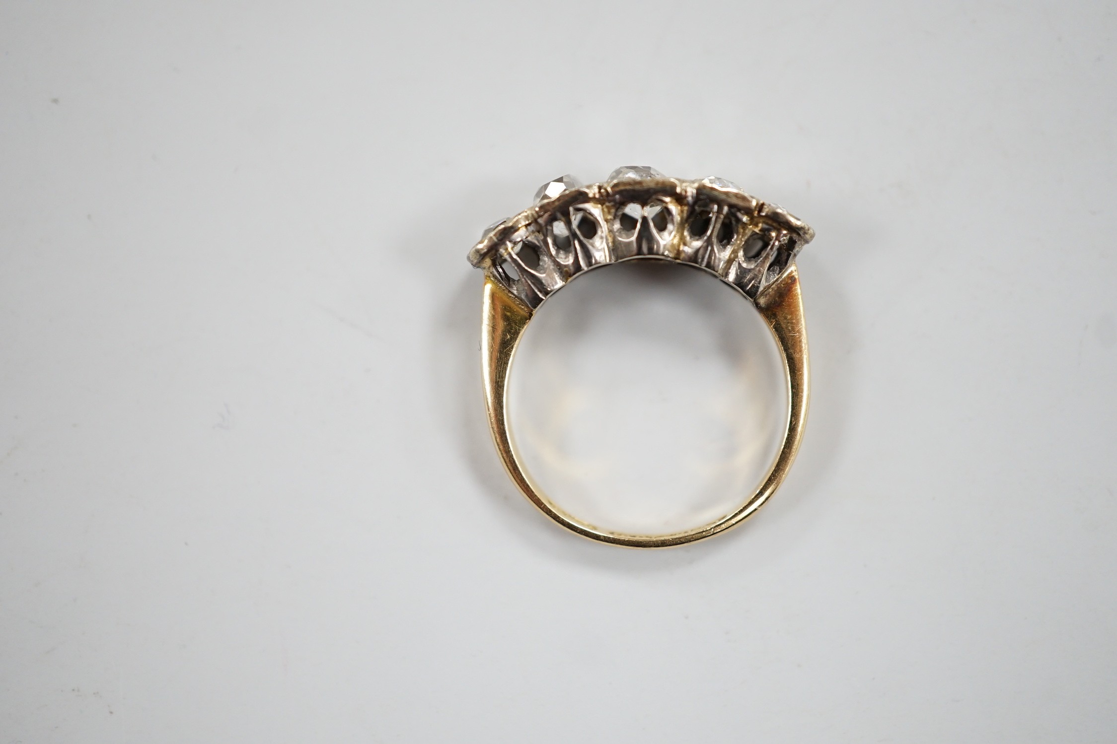 An 18ct, plat and graduated five stone diamond set half hoop ring, size J/K, gross weight 3.3 grams.